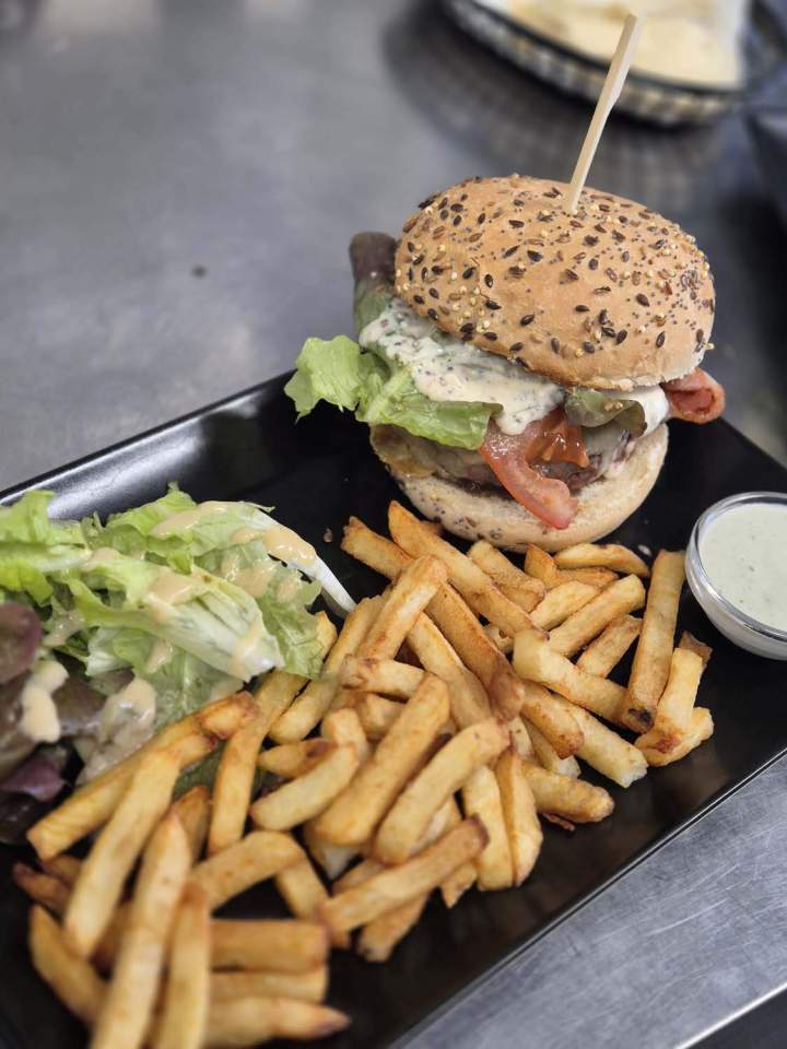 Burger servi avec des frites et une salade Les Ancizes-Comps
